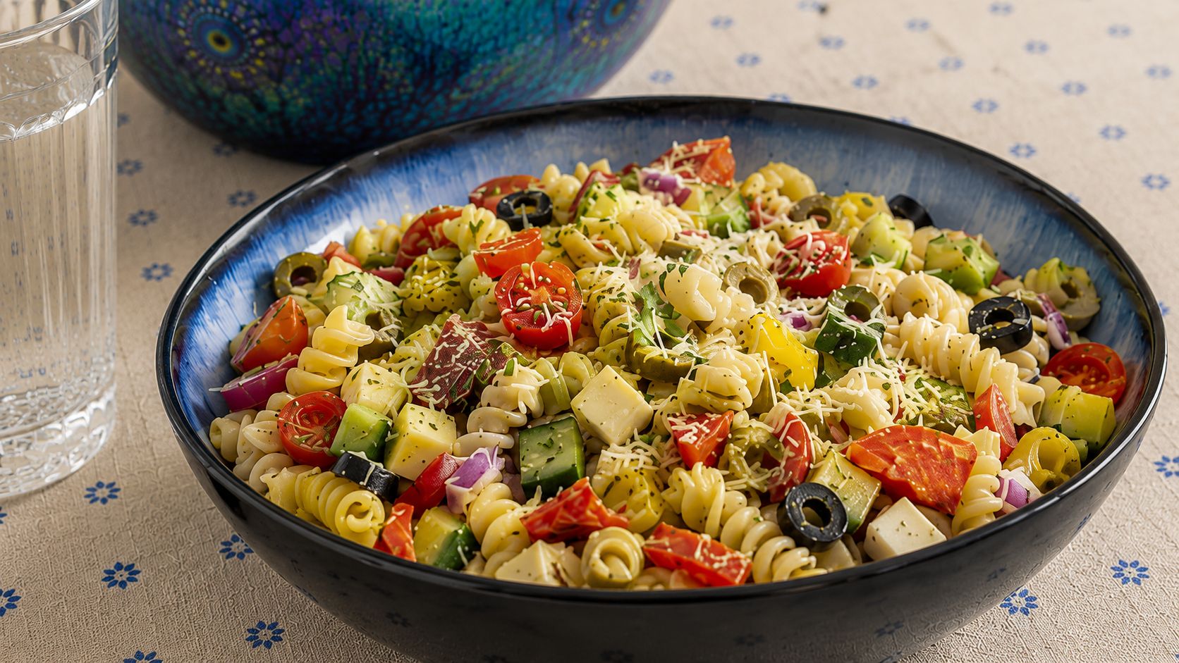 Large bowl of classic Italian pasta salad with rotini, cherry tomatoes, olives, pepperoni, and provolone tossed in Italian dressing