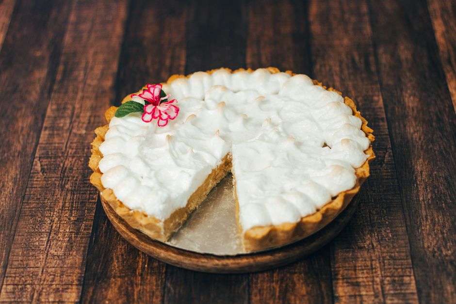 A golden-brown Southern sweet potato pie in a fluted pie dish with a perfectly set custardy filling, one slice removed to show the smooth orange interior
